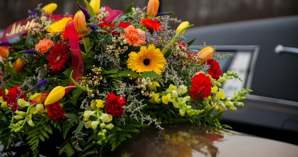 Funeral Casket and flowers next to hearse