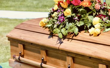 Lovely floral arrangement on wood casket.